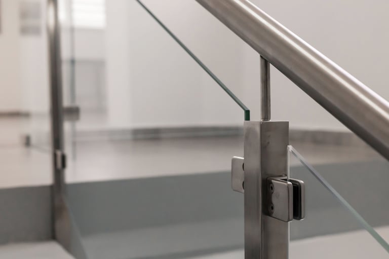 Vista cercana de barandal moderno de metal y vidrio en espacio interior minimalista con luz natural