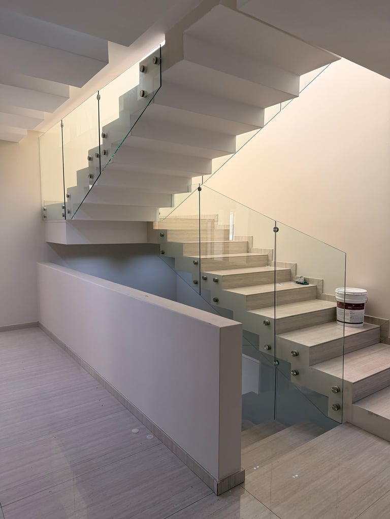 Escalera minimalista moderna con barandales de vidrio y escalones de madera clara en espacio interior contemporáneo brillante
